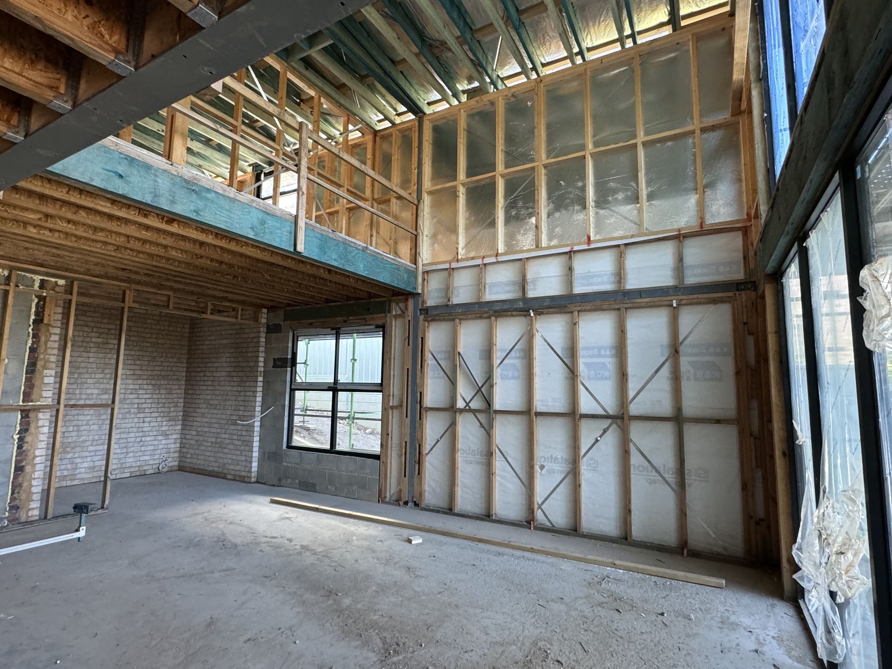Double-height living space with mezzanine framing and steel beam