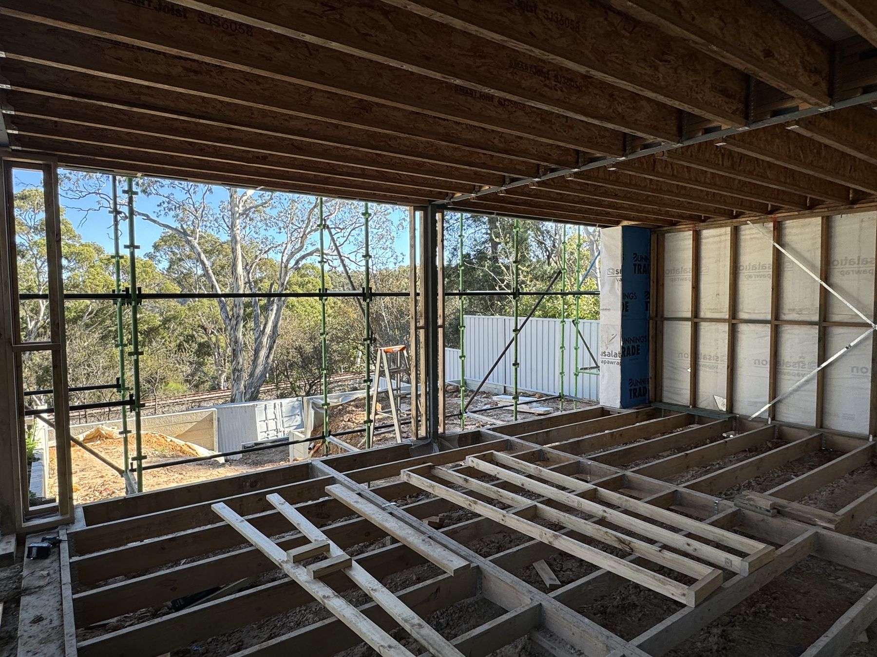 First-floor frame of a new build — engineered I-joists with bushland beyond